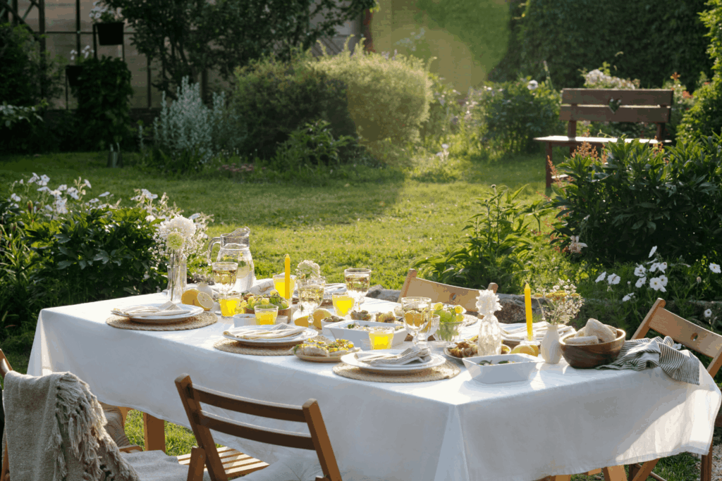 Gedeckter Gartentisch mit Sommersalaten, Limonade und Brot im goldenen Licht – Sommerküche für die Familie
