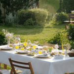 Gedeckter Gartentisch mit Sommersalaten, Limonade und Brot im goldenen Licht – Sommerküche für die Familie